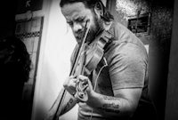 a man playing a violin in a black and white photo