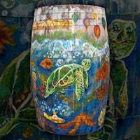 a painted barrel with sea turtles on it