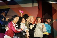 a group of people posing in front of a colorful wall