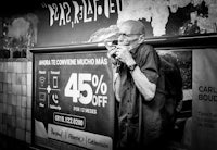 black and white photo of a man smoking a pipe in a subway station