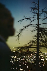 a man standing in front of a tree at night